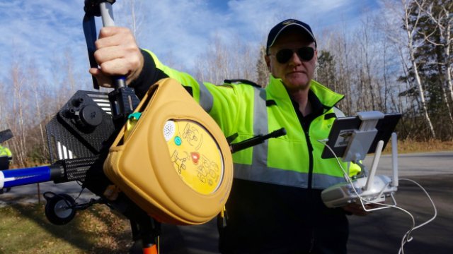 Brian Leahey, deputy chief of the County of Renfrew Paramedic Service, shows off a drone carrying a defibrillator during a demonstration in Carp, Ont., west of Ottawa this week. (Ashley Burke/CBC)