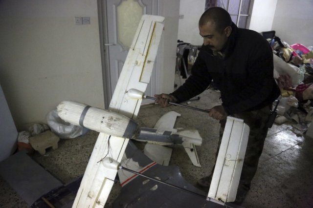 n this Friday, Jan. 27, 2017 photo, an Iraqi officer inspects drones belonging to Islamic State militants in Mosul, Iraq. Islamic State is hacking store-bought drone technology, using rigorous testing and tactics that mimic those used by U.S. unmanned aircraft to adapt to diminishing numbers of fighters and a battlefield that is increasingly difficult to navigate on the ground. (AP Photo/ Khalid Mohammed)