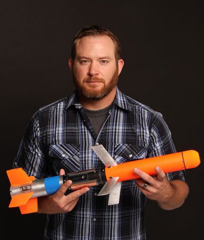 Jonathon Pooley, a technician at NAWCWD, displays a 25-inch, 5.5-pound forward-firing miniature munition known as Spike - U.S. Navy photo